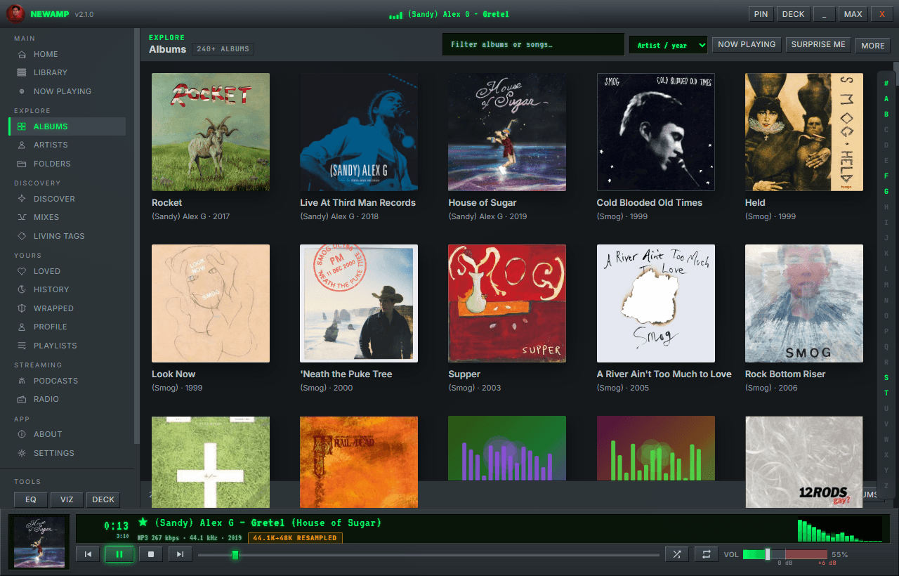 NewAmp's Albums view — a dense grid of real album covers with an alphabet rail, filter box, and Surprise Me button